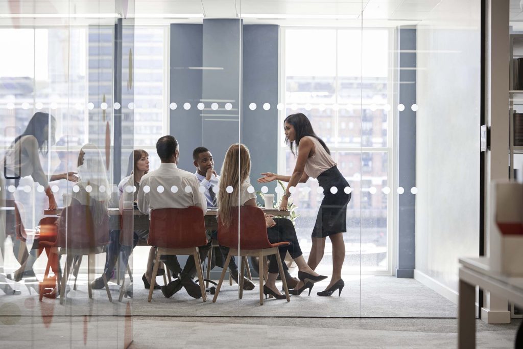 female-boss-stands-leaning-on-table-at-business-me-PD3WHMP.jpg